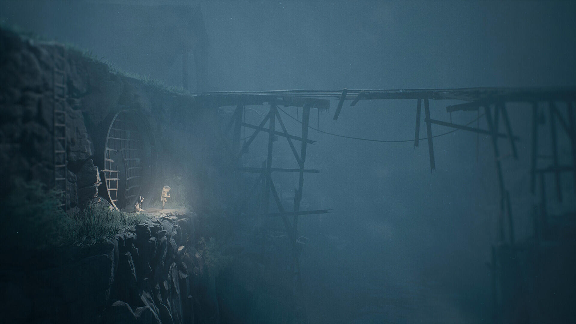 HD PC desktop wallpaper for horror game Reanimal: lone lantern-wielding figure on a rocky ledge beside a broken wooden bridge vanishing into thick fog and darkness.