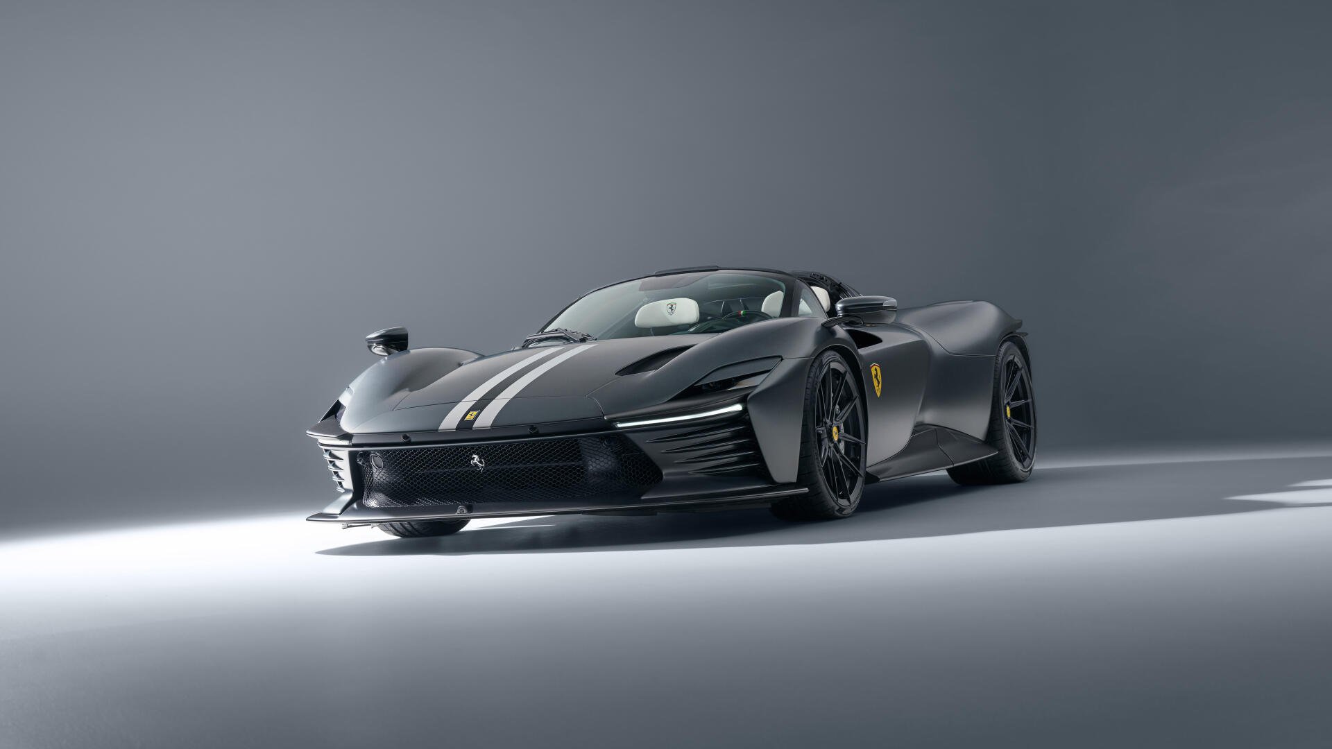 Black Ferrari Daytona SP3 in studio lighting, low-angle 8K Ultra HD PC desktop wallpaper highlighting a sleek profile, white racing stripe and glossy finish.