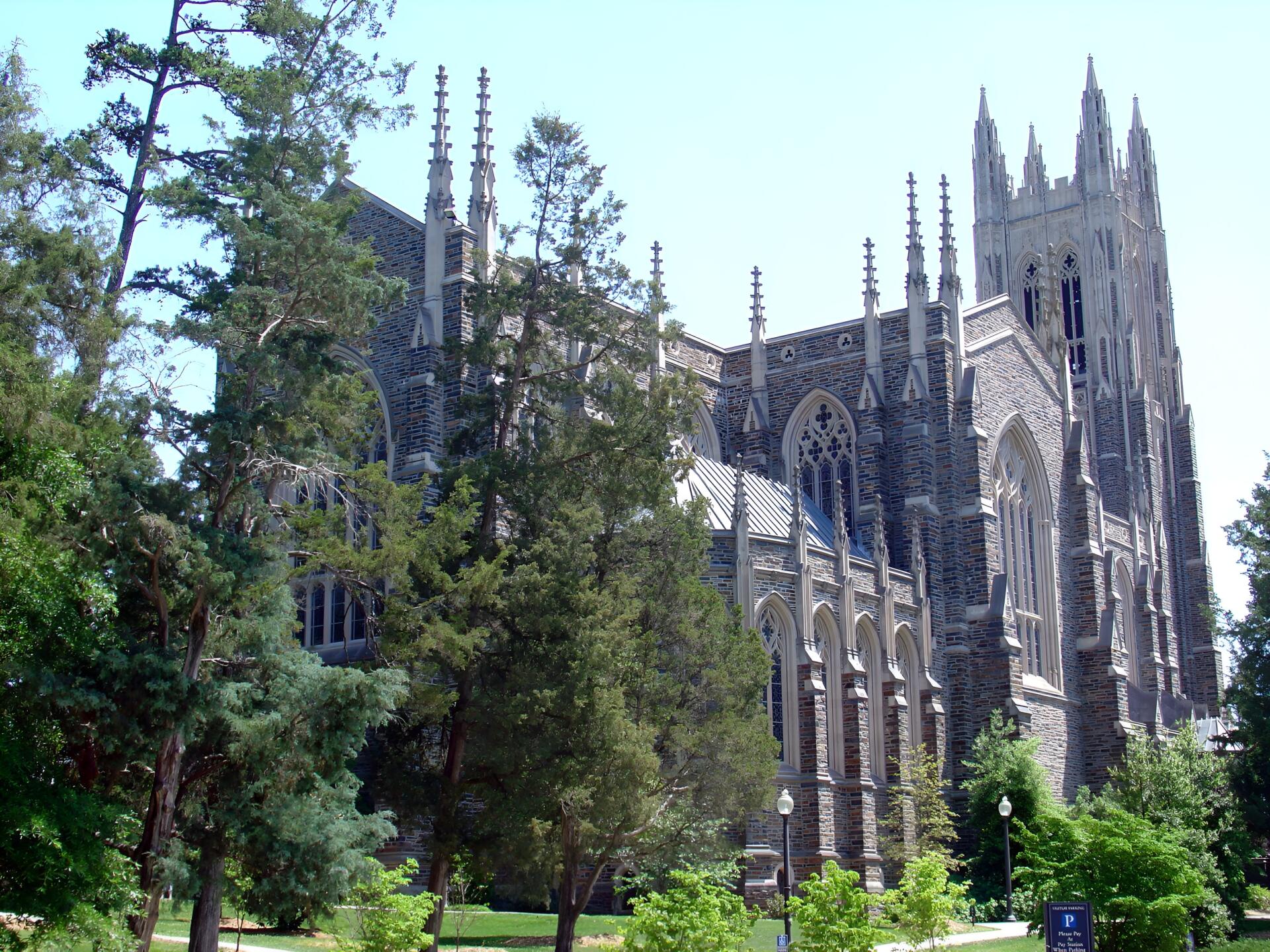 Duke University Gothic building with soaring spires and arched windows framed by trees, presented as a 2K Quad HD PC desktop wallpaper and background.