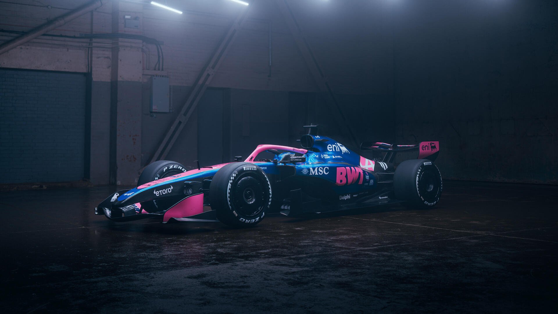 Alpine F1 Team race car in pink-and-blue livery parked under industrial lights in a dark garage, high-detail 4K Ultra HD PC desktop background.