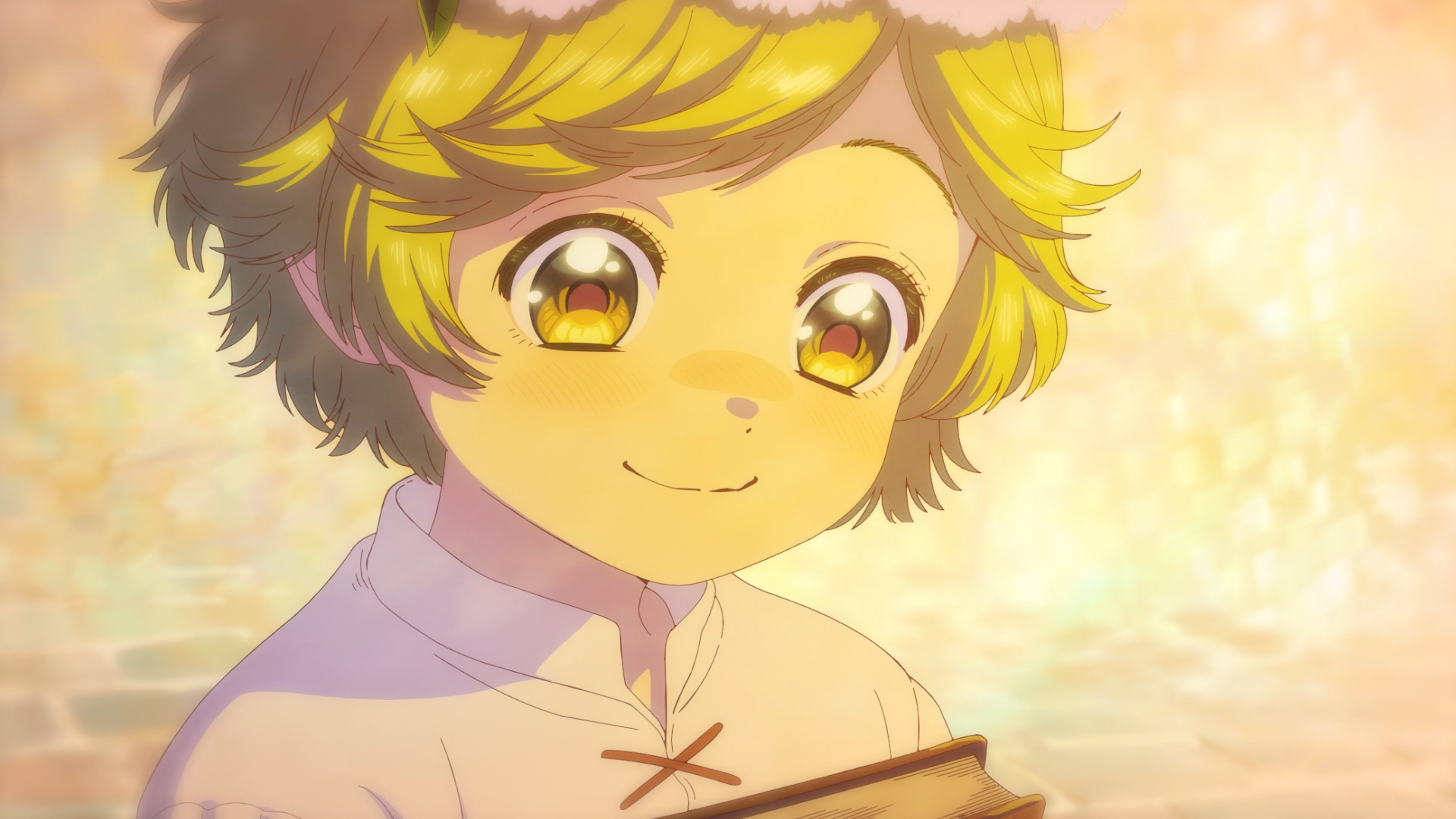 HD PC desktop wallpaper of Coco from Witch Hat Atelier — close-up anime portrait bathed in warm golden light, smiling gently while holding a book.