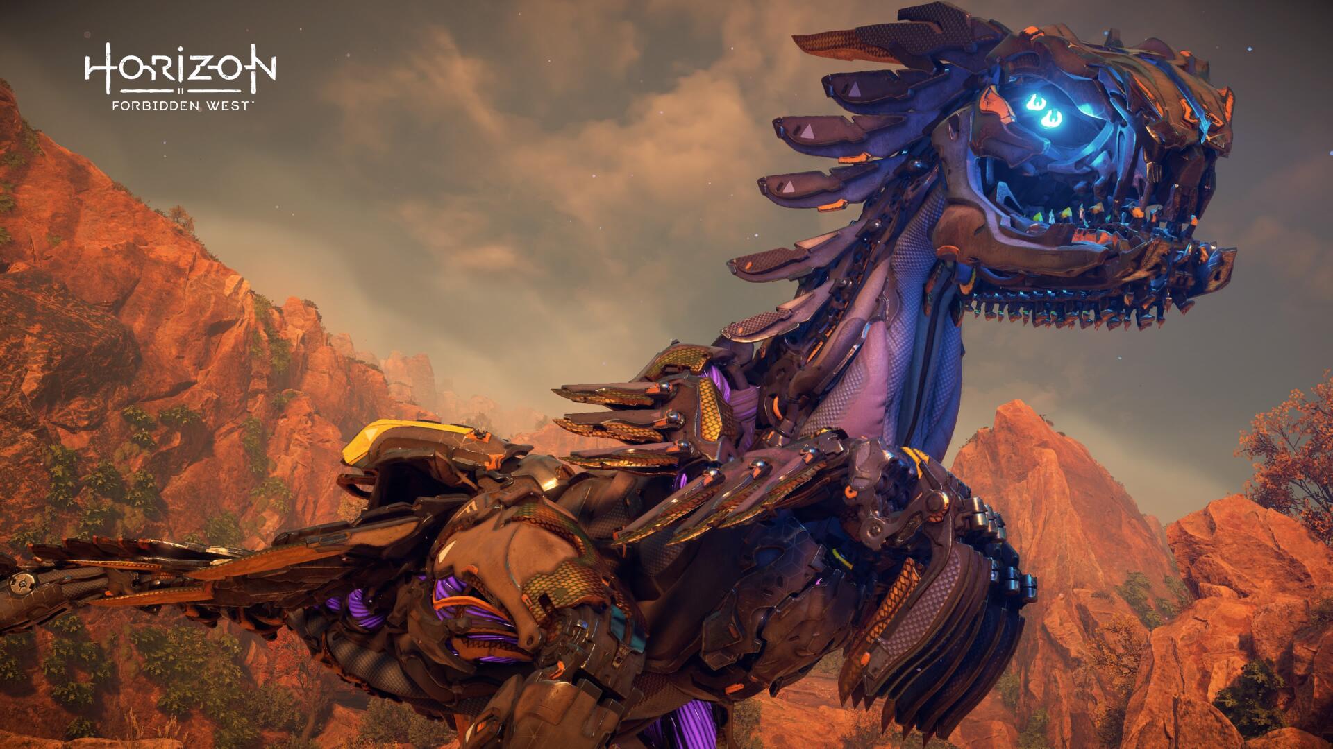 4K Ultra HD PC desktop wallpaper from the video game Horizon Forbidden West: close-up of a glowing blue-eyed machine-beast amid red rocky cliffs at sunset.