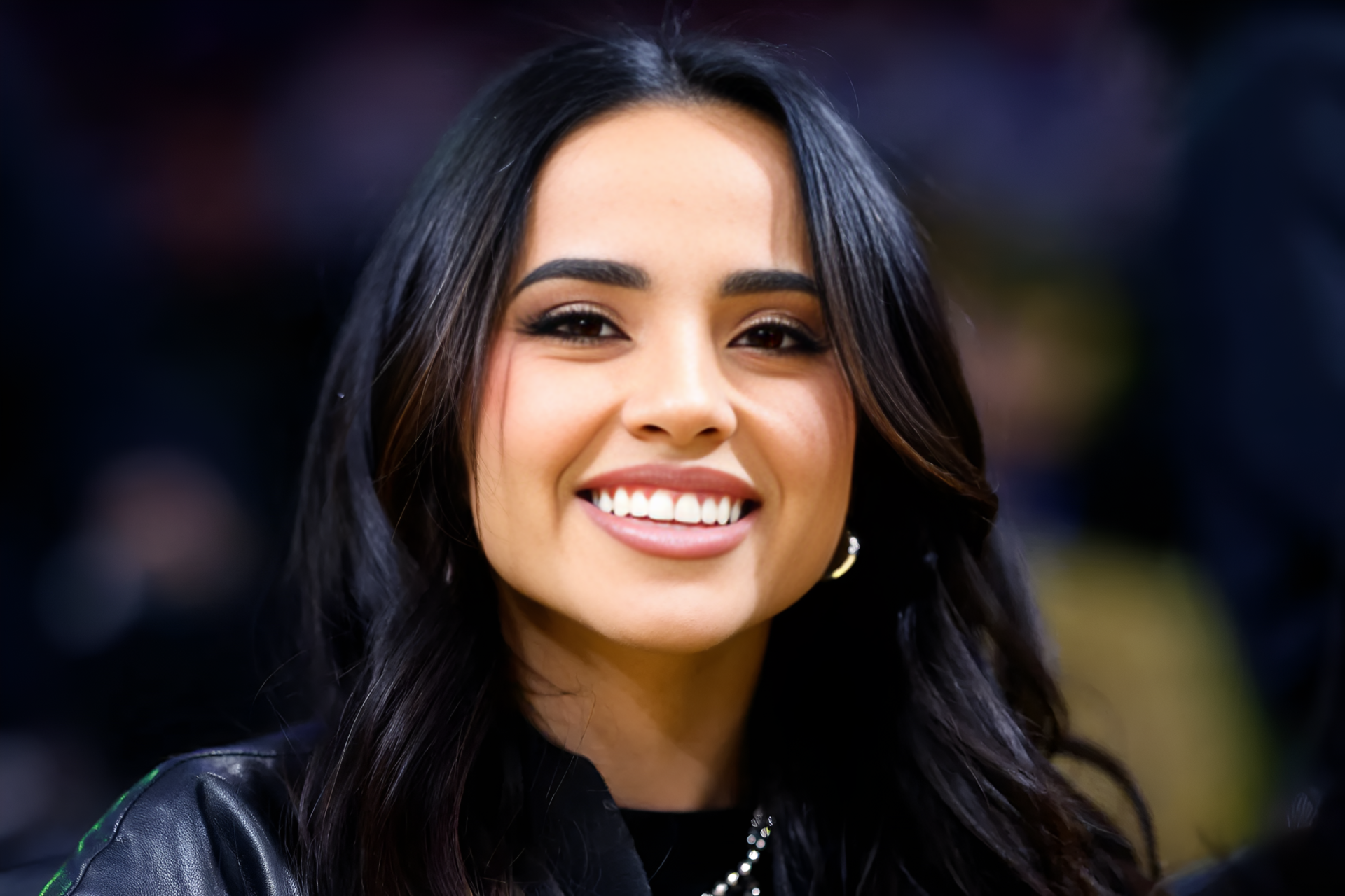 Close-up portrait of a smiling American singer with dark hair, music-themed 2K Quad HD PC desktop wallpaper and background.