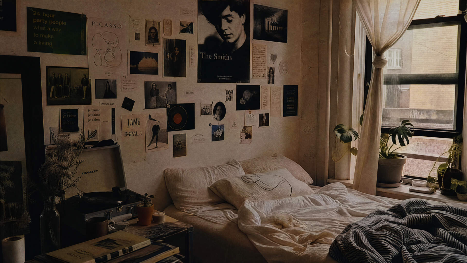 Cozy indie aesthetic bedroom: rumpled bed, collage of posters and photos above, potted plants by a curtained window — 4K Ultra HD PC Desktop Wallpaper and Background.