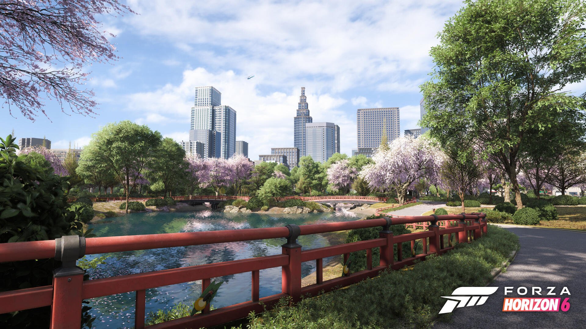 Forza Horizon 6 video game 4K Ultra HD PC desktop wallpaper: scenic park with red wooden bridge over a pond, cherry blossoms and trees, modern city skyline under a blue sky.
