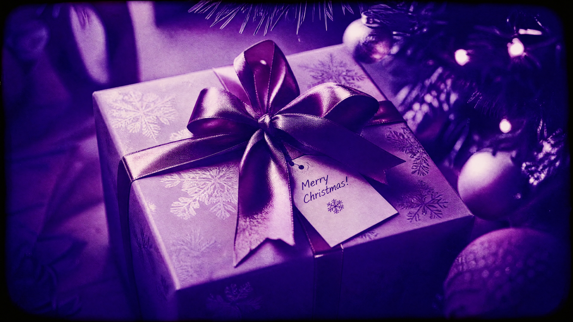 4K Ultra HD PC desktop wallpaper and background: close-up of a purple-wrapped Christmas gift with satin bow and tag beneath decorated tree ornaments.