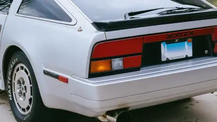 Close-up rear view of a white Nissan 300ZX retro car showing taillight, bumper and wheel - 4K Ultra HD PC desktop wallpaper/background.