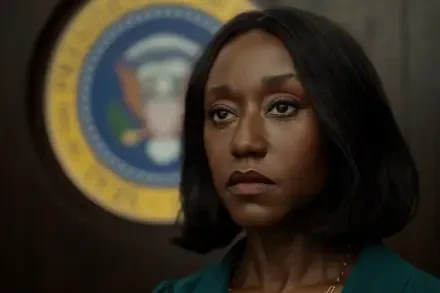 Close-up of a tearful character from the TV drama The Diplomat, solemn gaze with an official seal behind her — 2K Quad HD PC desktop wallpaper.