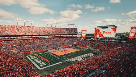 HD PC desktop wallpaper/background: aerial view of a packed NFL stadium during a Tampa Bay Buccaneers game, showing the field, fans, and jumbotron.
