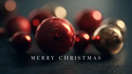 Close-up of red and gold Christmas ornaments and balls with Merry Christmas text, 2K Quad HD PC desktop wallpaper and background.