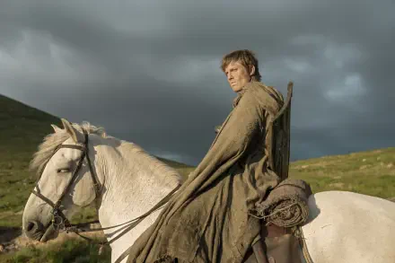 HD PC desktop wallpaper of a cloaked rider on a white horse in windswept hills — a scene from the TV show A Knight of the Seven Kingdoms