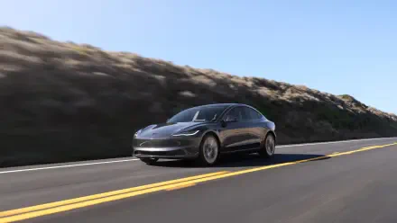 Sleek Tesla Model 3 electric car cruising on a sunlit highway, presented as a 4K Ultra HD PC desktop wallpaper background.