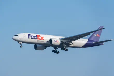FedEx delivery airplane in flight against a clear blue sky, 5K Ultra HD PC desktop wallpaper background.
