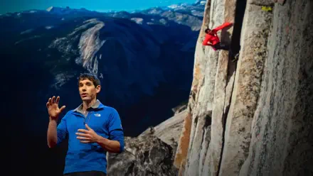 2K Quad HD PC wallpaper of a climber in a red jacket scaling a sheer granite wall above a vast valley, with a man in blue speaking in the foreground.