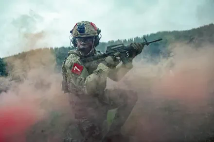 5K Ultra HD PC desktop wallpaper for the movie War Machine (2026): a helmeted soldier aims a rifle through swirling colored battlefield smoke.