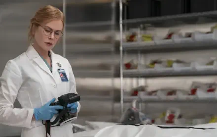 TV show scene: female doctor in white lab coat and blue gloves inspects a covered body in a clinical morgue — 2K Quad HD PC desktop wallpaper.