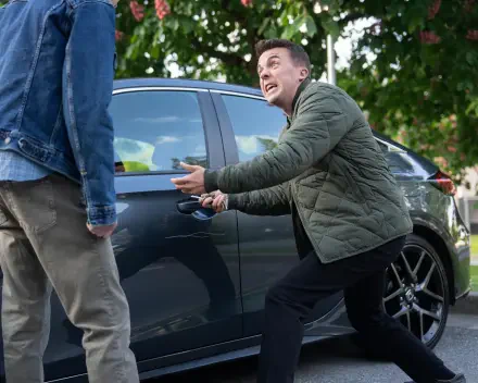 Man in green jacket opening a car door, animatedly talking to someone off-frame; 2K Quad HD desktop wallpaper inspired by TV show Malcolm in the Middle: Life's Still Unfair.