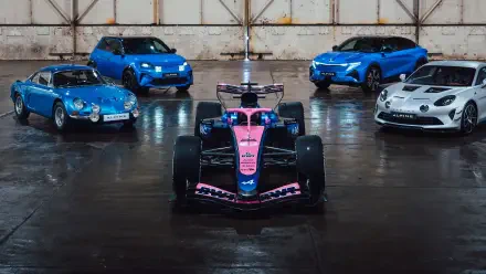 4K Ultra HD desktop wallpaper: Alpine F1 Team pink-and-blue Formula 1 car front and center, flanked by blue and white Alpine road cars in a reflective hangar.