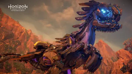 4K Ultra HD PC desktop wallpaper from the video game Horizon Forbidden West: close-up of a glowing blue-eyed machine-beast amid red rocky cliffs at sunset.