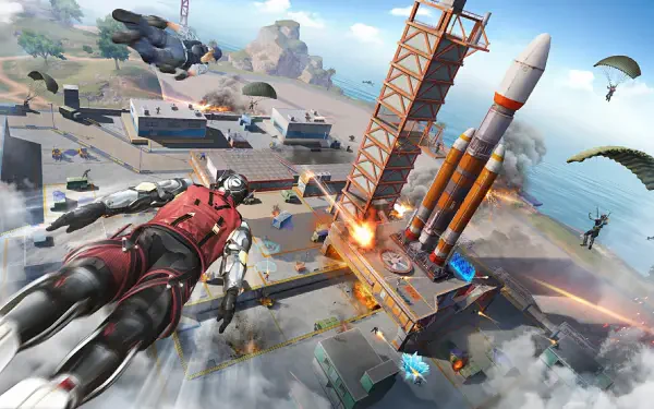 HD PC desktop wallpaper for the video game Blood Strike: armored jumper dives toward a rocket launch pad amid explosions, parachutes, and high-octane coastal battlefield action.