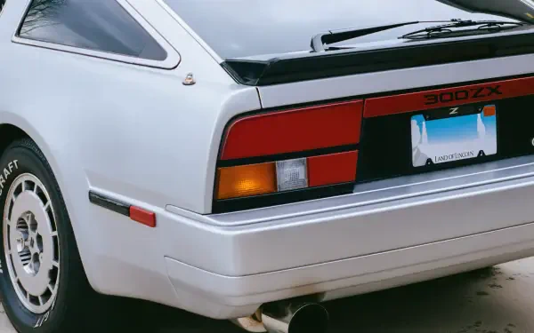 Close-up rear view of a white Nissan 300ZX retro car showing taillight, bumper and wheel - 4K Ultra HD PC desktop wallpaper/background.