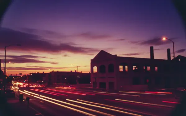 HD PC desktop wallpaper and background: long-exposure dusk cityscape with streaking car lights, silhouetted buildings and a purple-orange sky.