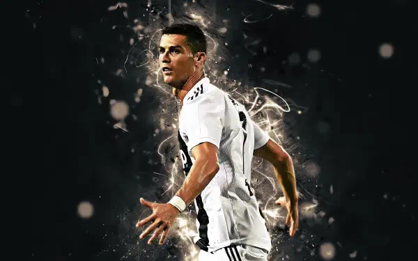 Sports-themed 2K Quad HD desktop wallpaper of a footballer in a Juventus F.C. kit striking a dramatic pose amid glowing, explosive energy effects.