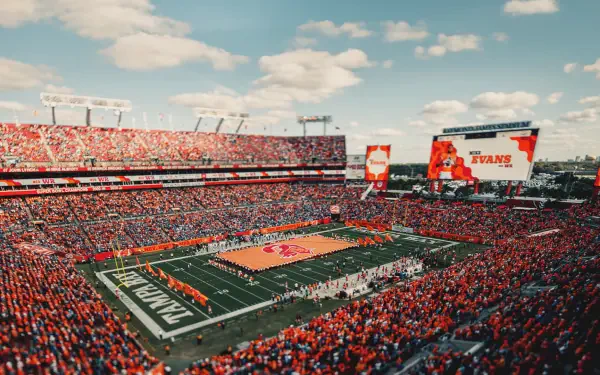 HD PC desktop wallpaper/background: aerial view of a packed NFL stadium during a Tampa Bay Buccaneers game, showing the field, fans, and jumbotron.