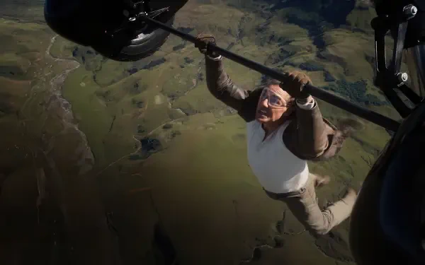 Mission: Impossible - The Final Reckoning 4K Ultra HD PC desktop wallpaper: a man clinging to a helicopter strut over rolling green countryside.