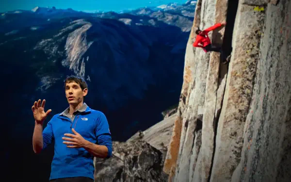 2K Quad HD PC wallpaper of a climber in a red jacket scaling a sheer granite wall above a vast valley, with a man in blue speaking in the foreground.