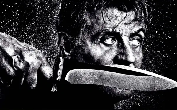 Rambo: Last Blood 4K Ultra HD PC desktop wallpaper — black-and-white close-up of a rugged man holding a large combat knife to his jaw, intense, watchful eyes.