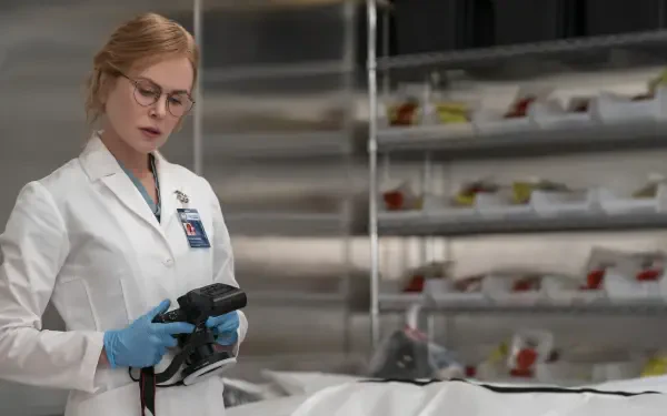 TV show scene: female doctor in white lab coat and blue gloves inspects a covered body in a clinical morgue — 2K Quad HD PC desktop wallpaper.