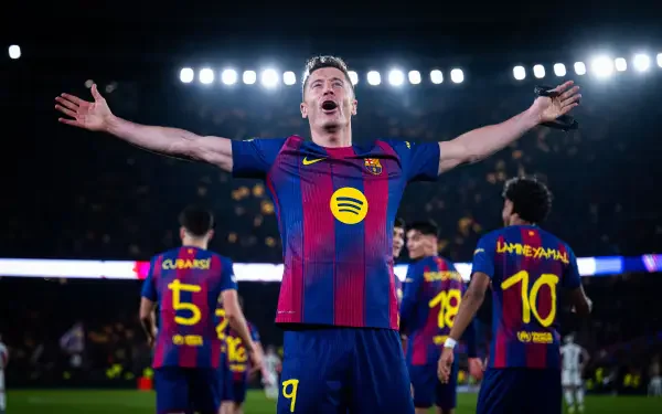 FC Barcelona player celebrates with arms outstretched as teammates gather under stadium lights — 4K Ultra HD soccer PC desktop wallpaper