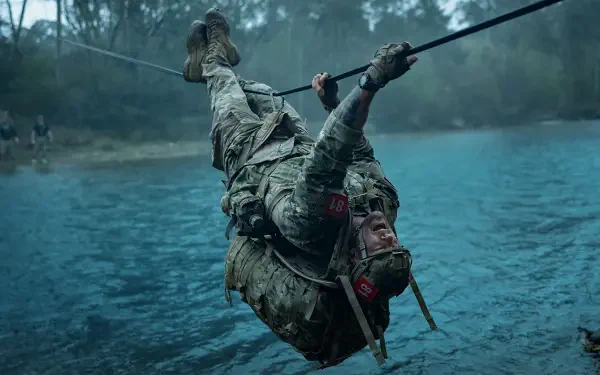 War Machine (2026) 4K Ultra HD PC desktop wallpaper - armored soldier in combat gear dangling from a rope above teal water, rain and mist-shrouded forest in the background.