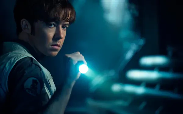TV show character from Alien: Earth holds a flashlight in a dark, moody scene — 2K Quad HD PC desktop wallpaper background.