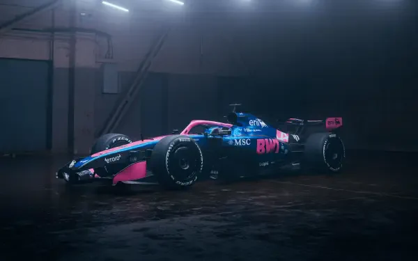 Alpine F1 Team race car in pink-and-blue livery parked under industrial lights in a dark garage, high-detail 4K Ultra HD PC desktop background.