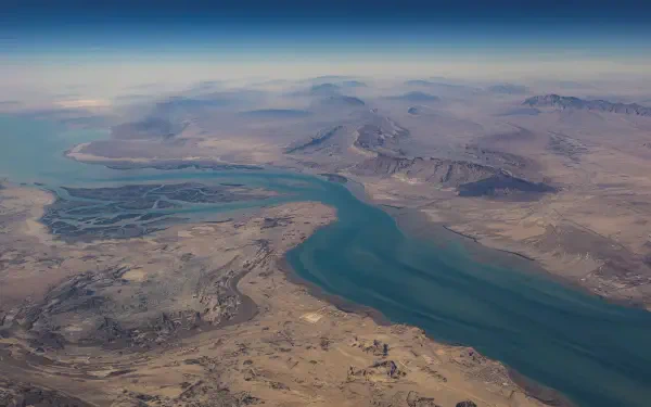 Aerial view of the Strait of Hormuz where the Persian Gulf meets the Gulf of Oman, arid coastline and turquoise channel — 2K Quad HD PC desktop wallpaper background.