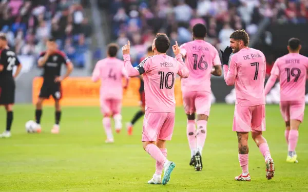 8K Ultra HD PC desktop wallpaper: Inter Miami CF soccer players in pink kits celebrate on the pitch, featuring jersey numbers 10 and 7 in a packed stadium atmosphere.