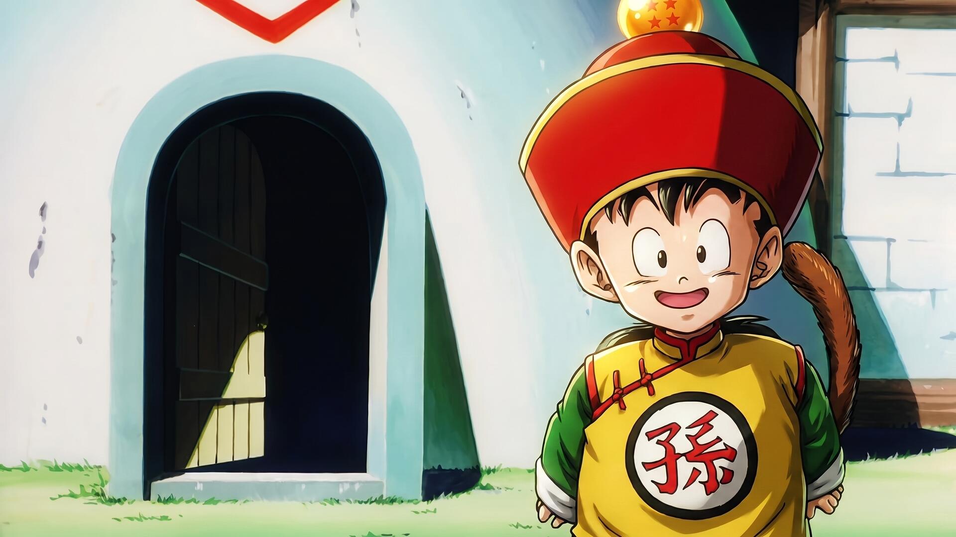 HD PC desktop wallpaper of young Gohan from Dragon Ball Z, anime scene outside a small white house, smiling in traditional outfit with red hat and tail.
