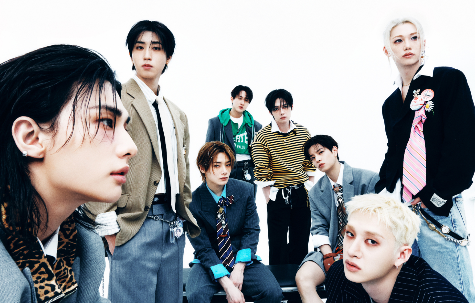 HD desktop wallpaper of an eight-member K-pop boy group, members seated and standing in coordinated suits and casual outfits against a clean white background.