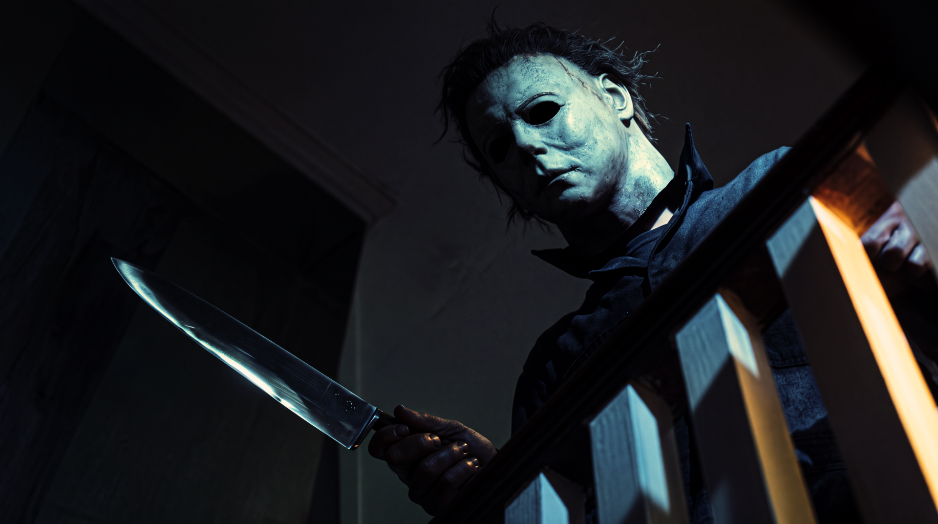 Michael Myers looms with a knife in a dark Halloween (1978) slasher scene, 5K Ultra HD PC desktop wallpaper and background.