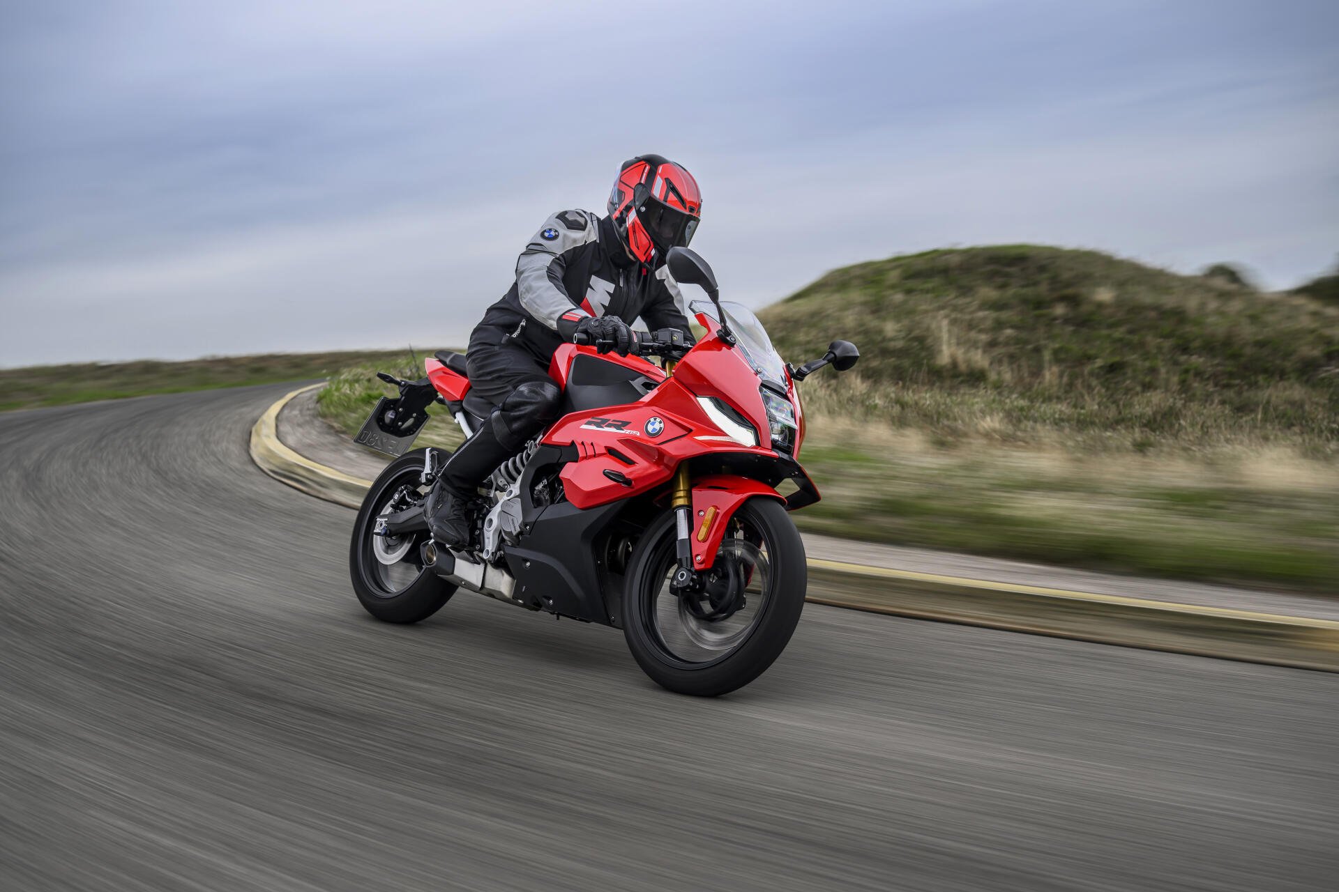BMW Motorrad F 450 RR sport motorcycle ridden on a winding road, featured in an 8K Ultra HD PC desktop wallpaper.