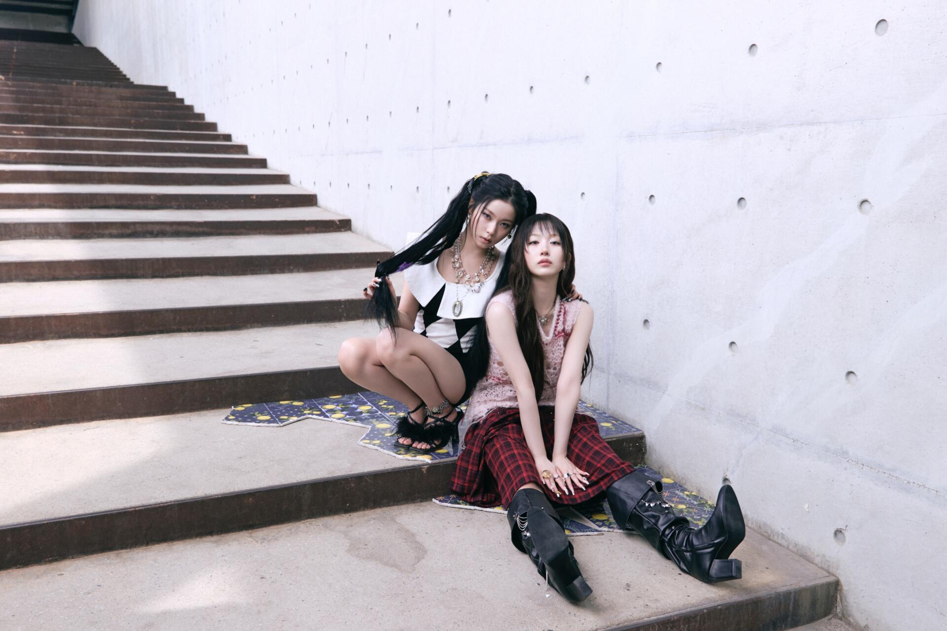 NMIXX Strange Muse 4K Ultra HD desktop wallpaper featuring two women in edgy fashion seated on concrete stairs.