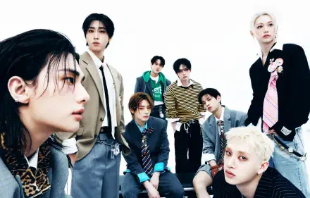 HD desktop wallpaper of an eight-member K-pop boy group, members seated and standing in coordinated suits and casual outfits against a clean white background.