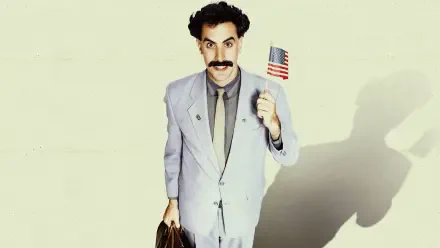 Borat Subsequent Moviefilm 4K Ultra HD PC desktop wallpaper: the Borat character in a light gray suit holding a small U.S. flag and briefcase, casting a long shadow on a pale background.