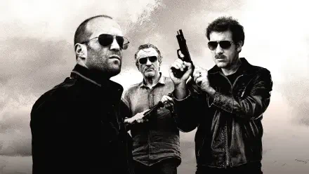 Killer Elite 4K Ultra HD PC desktop wallpaper: gritty black-and-white shot of three armed men in sunglasses and leather jackets against a stormy sky.