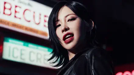 5K Ultra HD desktop wallpaper: close-up of a vampiric, K-pop–styled woman with dark hair, red lips and leather jacket, lit by neon signs.