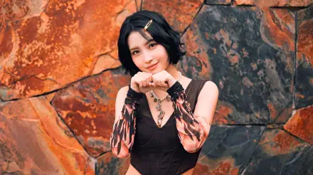 5K Ultra HD desktop wallpaper: short-haired Japanese model posing with hands near her face against a rusted stone backdrop, styled in a K-pop idol TWICE/MiSaMo aesthetic.