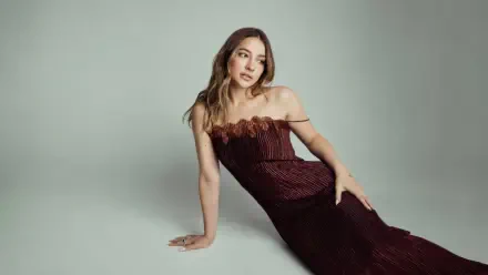 Studio portrait of a young woman reclining in a strapless burgundy gown on a light gray backdrop — 4K Ultra HD desktop wallpaper.