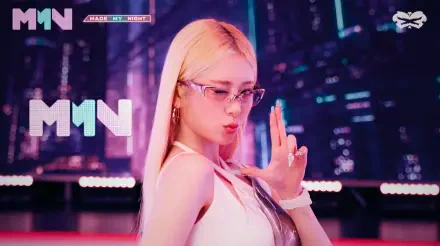 Blonde K-pop idol in glasses striking a finger-gun pose against a neon, Overwatch 2–style cityscape; vibrant pink and cyan lighting, 5K Ultra HD PC desktop wallpaper.